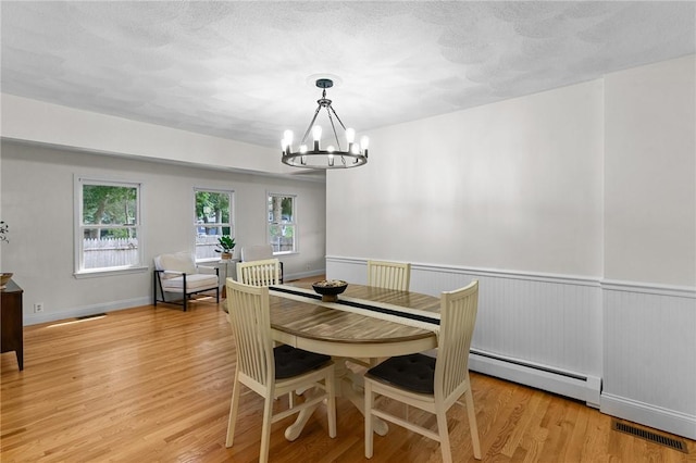 188 Reynolds Ave, Warwick, RI 02889 - dining area featuring a chandelier, a baseboard heating unit, and light wood-style flooring