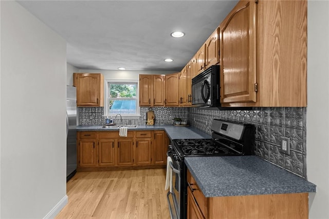 188 Reynolds Ave, Warwick, RI 02889 - kitchen with appliances with stainless steel finishes, brown cabinetry, dark countertops, light wood-type flooring, and recessed lighting