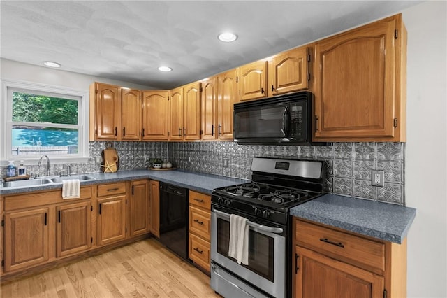 188 Reynolds Ave, Warwick, RI 02889 - kitchen featuring black appliances, dark countertops, light wood-style floors, tasteful backsplash, and recessed lighting