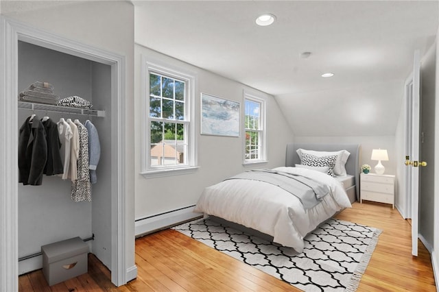 188 Reynolds Ave, Warwick, RI 02889 - bedroom featuring baseboard heating, light wood-type flooring, vaulted ceiling, a baseboard heating unit, and recessed lighting