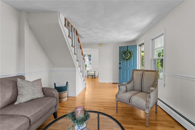 188 Reynolds Ave, Warwick, RI 02889 - living room with a baseboard radiator, light wood-style flooring, and stairs
