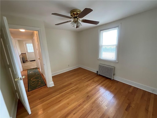 94 Alvin St, Warwick, RI 02886 - unfurnished room with radiator heating unit, light wood-style flooring, and ceiling fan