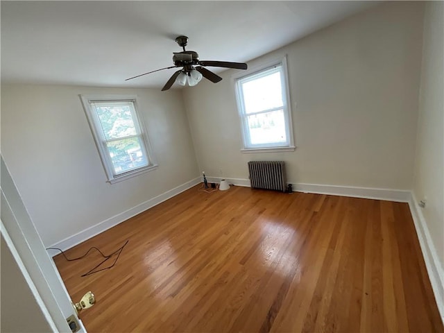 94 Alvin St, Warwick, RI 02886 - empty room with radiator heating unit, healthy amount of natural light, light wood finished floors, and a ceiling fan