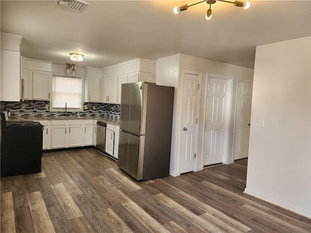 93 Dixon St Unit 1Front, Providence, RI 02907 - kitchen with stainless steel appliances, dark wood finished floors, white cabinetry, decorative backsplash, and light countertops