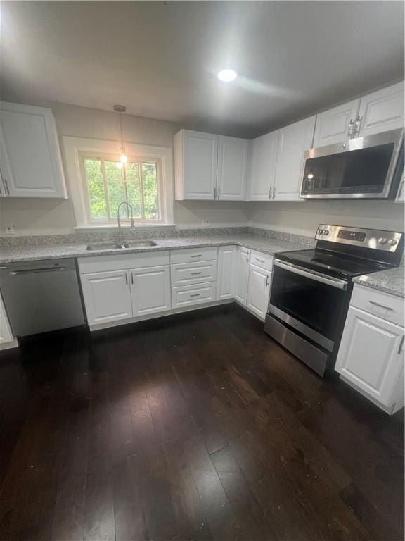 354 Rhodes Ave, Woonsocket, RI 02895 - kitchen featuring appliances with stainless steel finishes, dark wood-type flooring, white cabinetry, and light stone counters