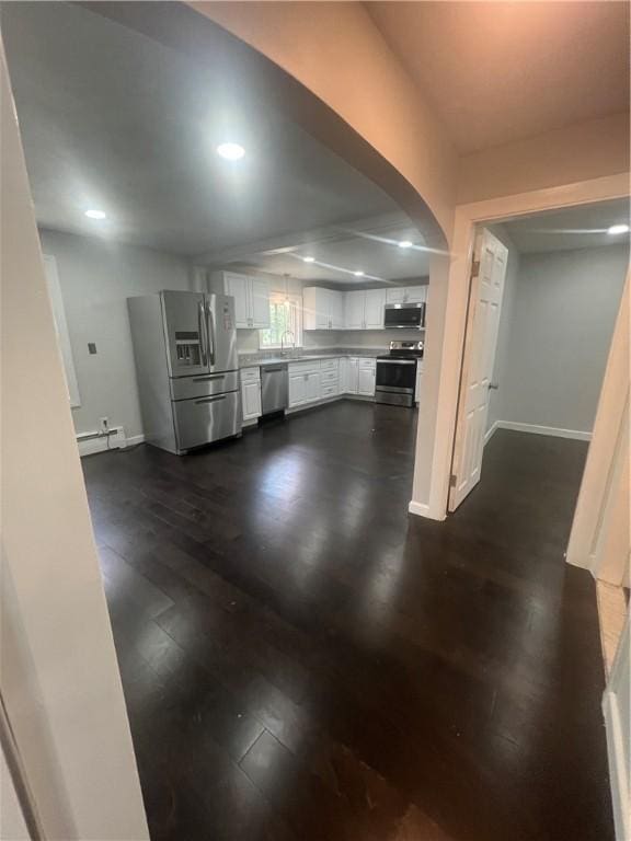 354 Rhodes Ave, Woonsocket, RI 02895 - unfurnished living room with a baseboard radiator, dark wood-style floors, recessed lighting, and arched walkways