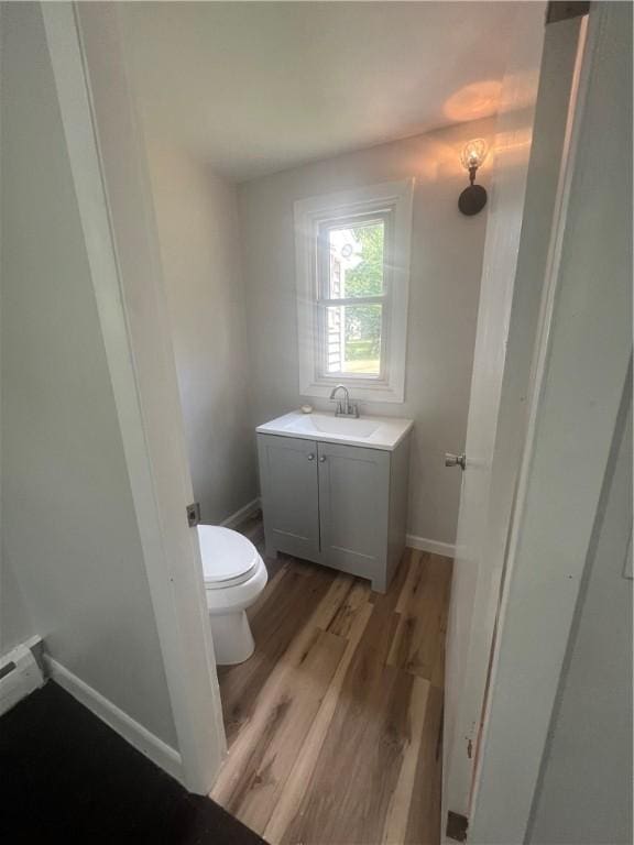 354 Rhodes Ave, Woonsocket, RI 02895 - bathroom with wood finished floors, vanity, and a baseboard heating unit