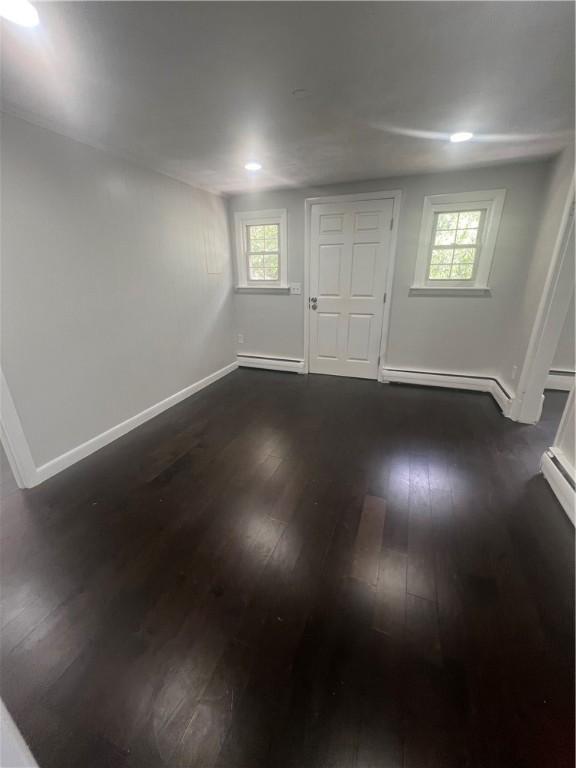 354 Rhodes Ave, Woonsocket, RI 02895 - foyer entrance with dark wood-style floors and a baseboard heating unit