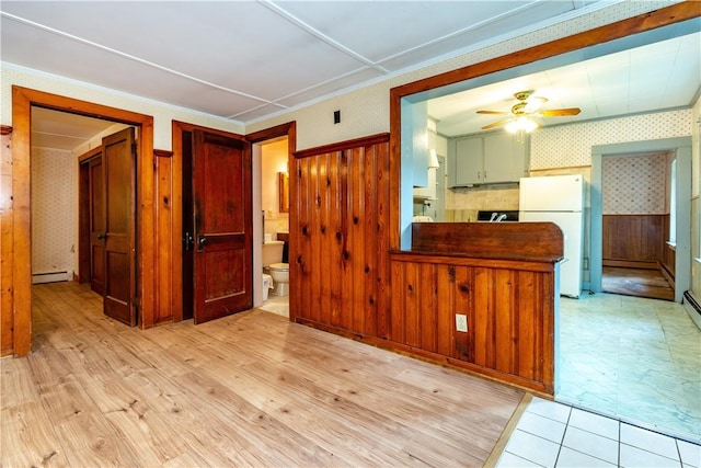 3442 Flat River Rd, Coventry, RI 02816 - kitchen featuring wallpapered walls, ceiling fan, baseboard heating, freestanding refrigerator, and wooden walls