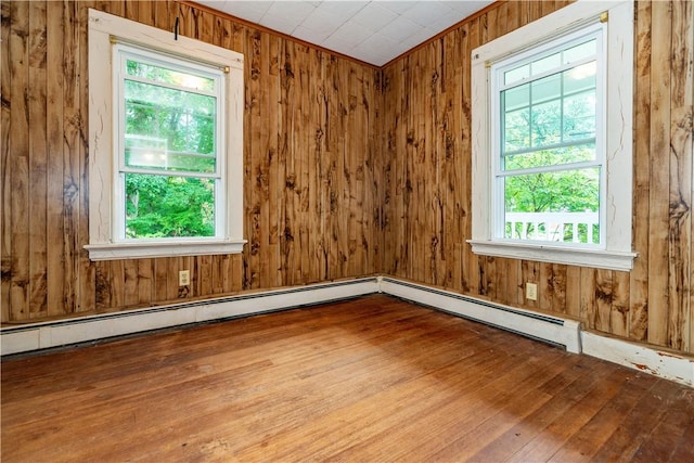 3442 Flat River Rd, Coventry, RI 02816 - spare room featuring hardwood / wood-style flooring, a baseboard heating unit, and wood walls