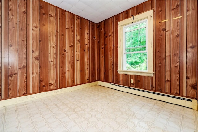 3442 Flat River Rd, Coventry, RI 02816 - empty room with a baseboard radiator, tile patterned floors, and wood walls