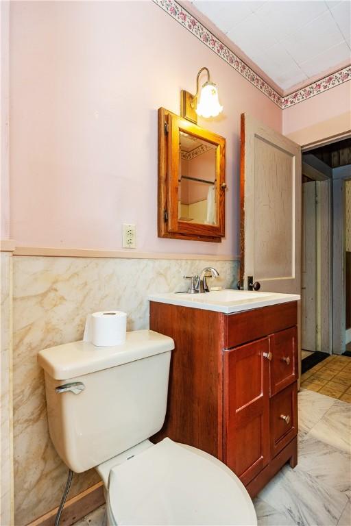 3442 Flat River Rd, Coventry, RI 02816 - bathroom with vanity, a wainscoted wall, and tile walls