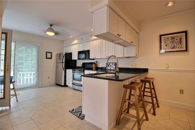 46 Highland Ave, Westerly, RI 02891 - kitchen with appliances with stainless steel finishes, a peninsula, light tile patterned floors, a kitchen breakfast bar, and white cabinets