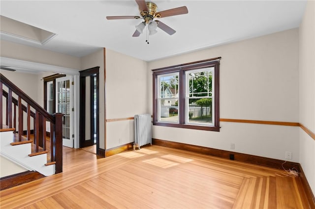 8 Parkman St, Providence, RI 02907 - foyer entrance with radiator, light wood finished floors, ceiling fan, and stairway