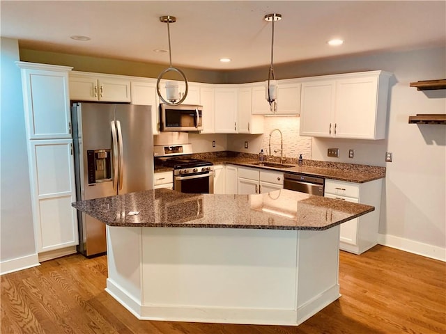 724 Centerville Rd Unit 6, Warwick, RI 02886 - kitchen with appliances with stainless steel finishes, white cabinetry, wood finished floors, decorative light fixtures, and dark stone countertops