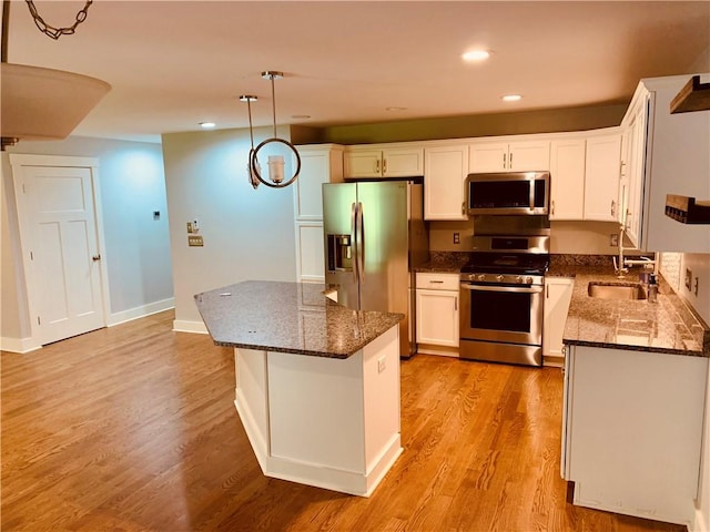 724 Centerville Rd Unit 6, Warwick, RI 02886 - kitchen with stainless steel appliances, white cabinetry, recessed lighting, dark stone counters, and decorative light fixtures
