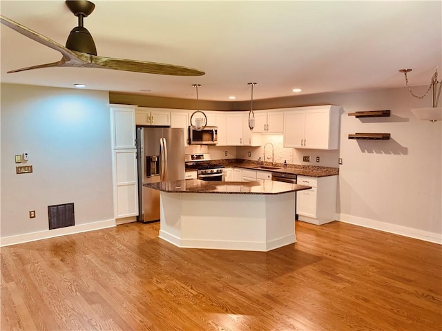 724 Centerville Rd Unit 6, Warwick, RI 02886 - kitchen featuring stainless steel appliances, a kitchen island, white cabinetry, hanging light fixtures, and light wood finished floors