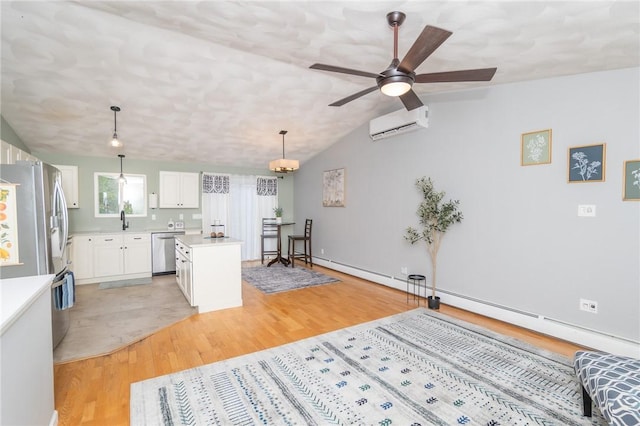 36 Wadsworth St, Warwick, RI 02889 - kitchen with appliances with stainless steel finishes, a wall mounted air conditioner, light wood-style flooring, a center island, and light countertops