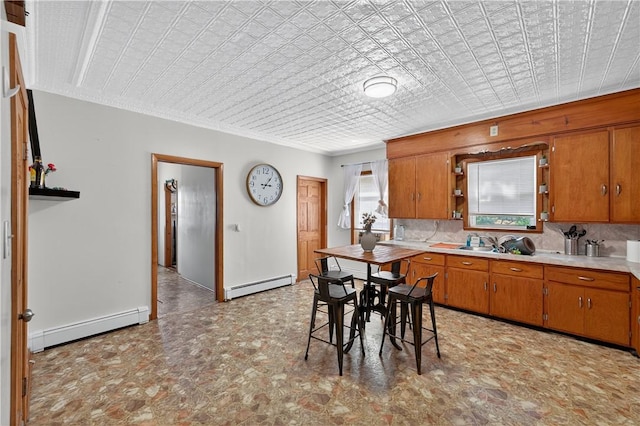 270 Central St, Central Falls, RI 02863 - kitchen with a baseboard heating unit, brown cabinetry, light countertops, and ornamental molding
