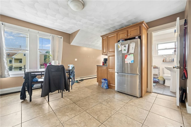 79 Winthrop St, Woonsocket, RI 02895 - kitchen featuring freestanding refrigerator, brown cabinetry, light tile patterned flooring, and a baseboard heating unit