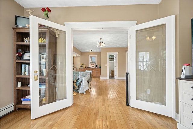 79 Winthrop St, Woonsocket, RI 02895 - hallway with baseboard heating, light wood-style floors, and a chandelier