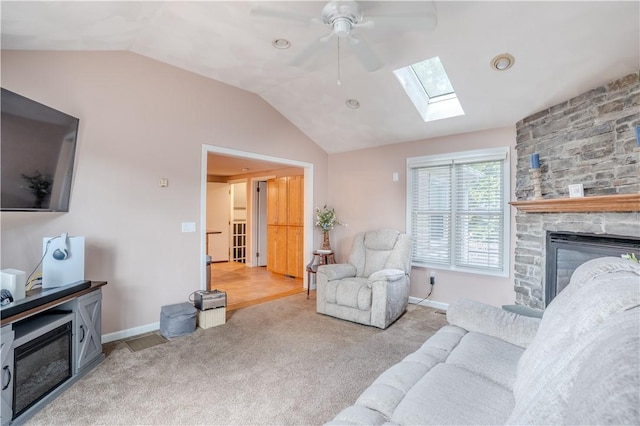 6 Jacksonia Dr, North Providence, RI 02911 - living area featuring a skylight, a stone fireplace, ceiling fan, lofted ceiling, and light carpet