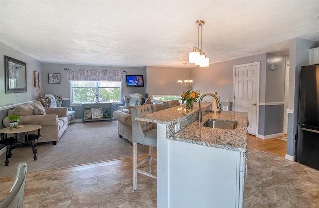 350 Narrow Ln, Charlestown, RI 02813 - kitchen with freestanding refrigerator, a breakfast bar area, open floor plan, light stone countertops, and pendant lighting
