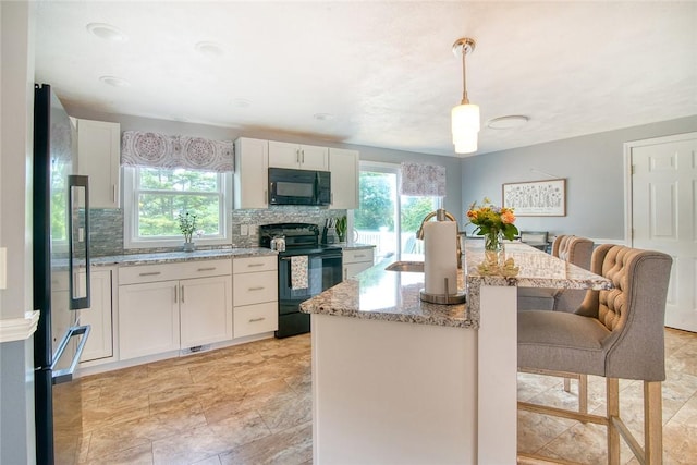 350 Narrow Ln, Charlestown, RI 02813 - kitchen with black appliances, healthy amount of natural light, a kitchen breakfast bar, and backsplash