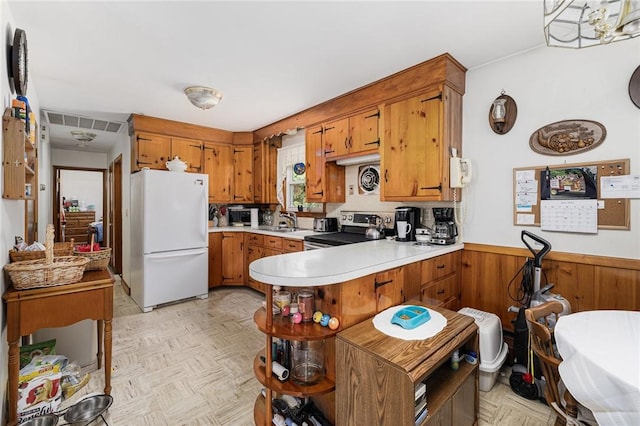 226 Westcott Rd, Scituate, RI 02857 - kitchen with appliances with stainless steel finishes, brown cabinets, light countertops, a peninsula, and a wainscoted wall