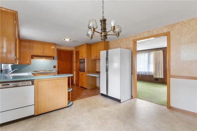 352 Cove Ave, Warwick, RI 02886 - kitchen with white appliances, wallpapered walls, under cabinet range hood, a chandelier, and light flooring