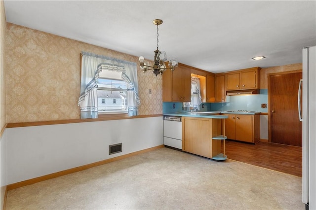 352 Cove Ave, Warwick, RI 02886 - kitchen with white dishwasher, under cabinet range hood, a chandelier, wallpapered walls, and freestanding refrigerator
