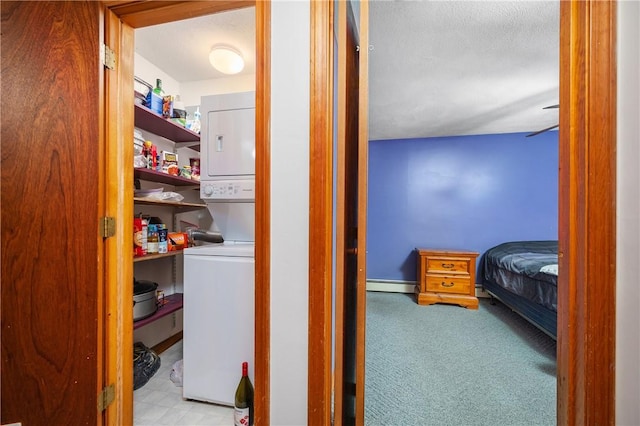 2 Angle St Unit 5, Lincoln, RI 02838 - pantry featuring stacked washing machine and dryer and a baseboard heating unit