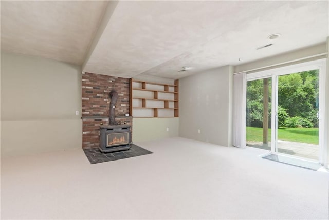 5 Spirketing St, Jamestown, RI 02835 - unfurnished living room featuring carpet floors and a wood stove