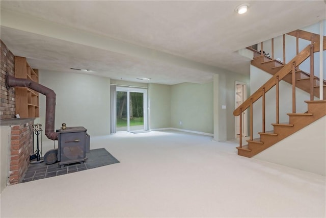 5 Spirketing St, Jamestown, RI 02835 - unfurnished living room featuring a wood stove, carpet flooring, and stairway