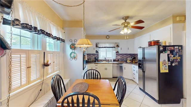 95 Burlington St, Providence, RI 02906 - kitchen with stainless steel appliances, decorative backsplash, ceiling fan, dark countertops, and white cabinetry