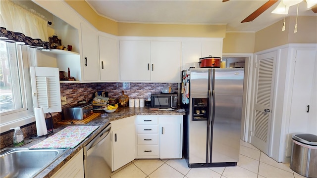 95 Burlington St, Providence, RI 02906 - kitchen with stainless steel appliances, light tile patterned floors, a ceiling fan, white cabinets, and ornamental molding