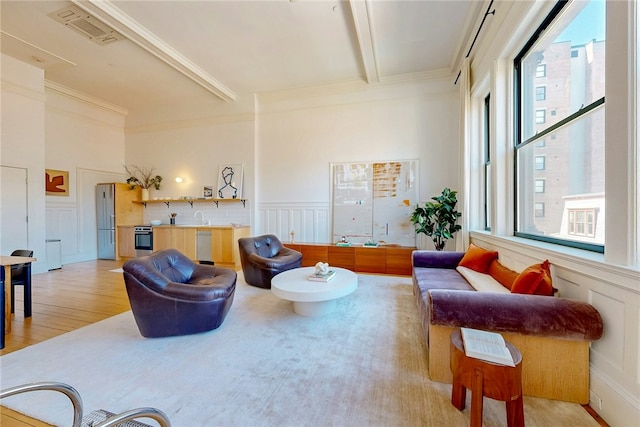 225 Weybosset St Unit 12, Providence, RI 02903 - living room featuring a decorative wall, healthy amount of natural light, beamed ceiling, light wood-style floors, and wainscoting
