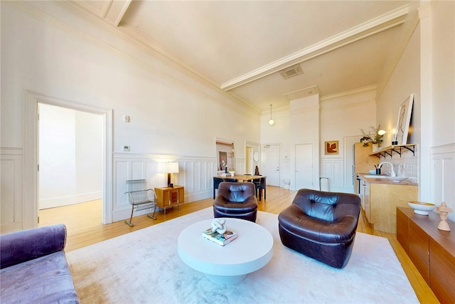 225 Weybosset St Unit 12, Providence, RI 02903 - sitting room with a decorative wall, light wood-style flooring, a high ceiling, crown molding, and a wainscoted wall