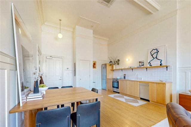 225 Weybosset St Unit 12, Providence, RI 02903 - dining room with a high ceiling, crown molding, light wood-style floors, and a decorative wall