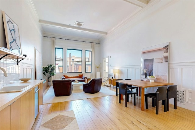225 Weybosset St Unit 12, Providence, RI 02903 - living area with light wood-style floors, crown molding, a wainscoted wall, and a decorative wall