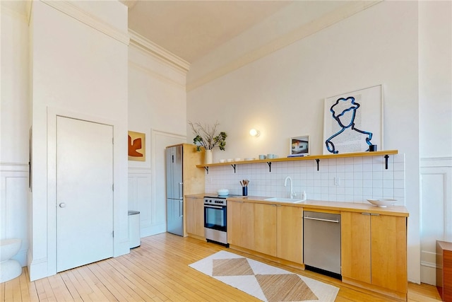 225 Weybosset St Unit 12, Providence, RI 02903 - kitchen with appliances with stainless steel finishes, open shelves, light wood-style floors, light countertops, and crown molding