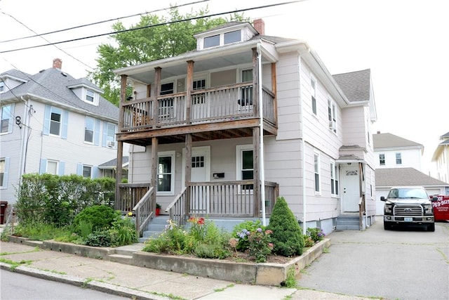 35 Merida Ave, Woonsocket, RI 02895 - view of front of house featuring a balcony, covered porch, and driveway