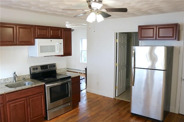 35 Merida Ave, Woonsocket, RI 02895 - kitchen with stainless steel appliances, light stone counters, a ceiling fan, wood finished floors, and a baseboard heating unit