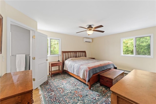 106 Lauri Dr, Charlestown, RI 02813 - bedroom with a wall mounted air conditioner, light wood-style floors, ceiling fan, and a baseboard radiator