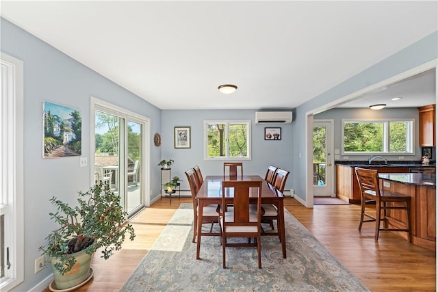 106 Lauri Dr, Charlestown, RI 02813 - dining space with a wall unit AC, light wood-type flooring, and healthy amount of natural light