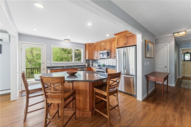 106 Lauri Dr, Charlestown, RI 02813 - kitchen with appliances with stainless steel finishes, light wood-type flooring, a center island, a kitchen bar, and recessed lighting