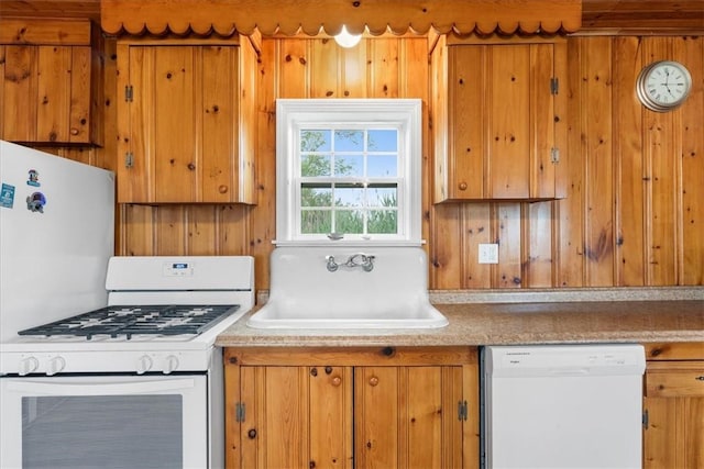 2 Geraldine Blvd, Narragansett, RI 02882 - kitchen with white appliances, brown cabinets, wood walls, and light countertops