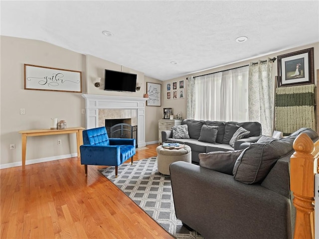 15 Sycamore Dr, West Warwick, RI 02893 - living room with lofted ceiling, wood finished floors, a tile fireplace, and recessed lighting
