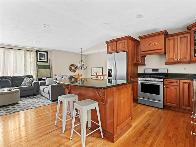 15 Sycamore Dr, West Warwick, RI 02893 - kitchen featuring appliances with stainless steel finishes, a kitchen bar, light wood-type flooring, a kitchen island, and lofted ceiling