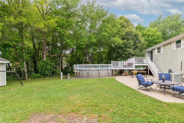 15 Sycamore Dr, West Warwick, RI 02893 - view of green lawn with a wooden deck, an outdoor pool, view of scattered trees, a patio, and stairs
